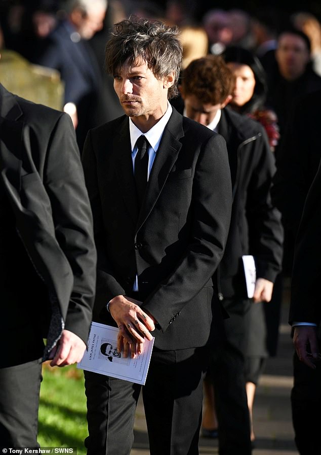 Louis Tomlinson leaves the church with an order of service after today's funeral.