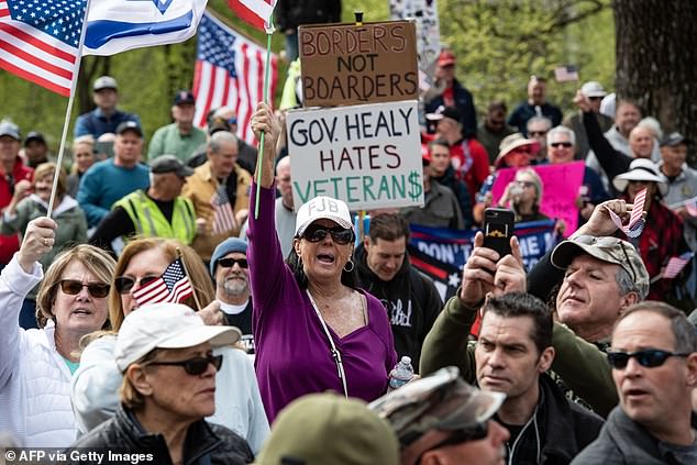 People hold signs and flags at a 'Close the Border' rally in Boston, Massachusetts, on May 4, 2024.