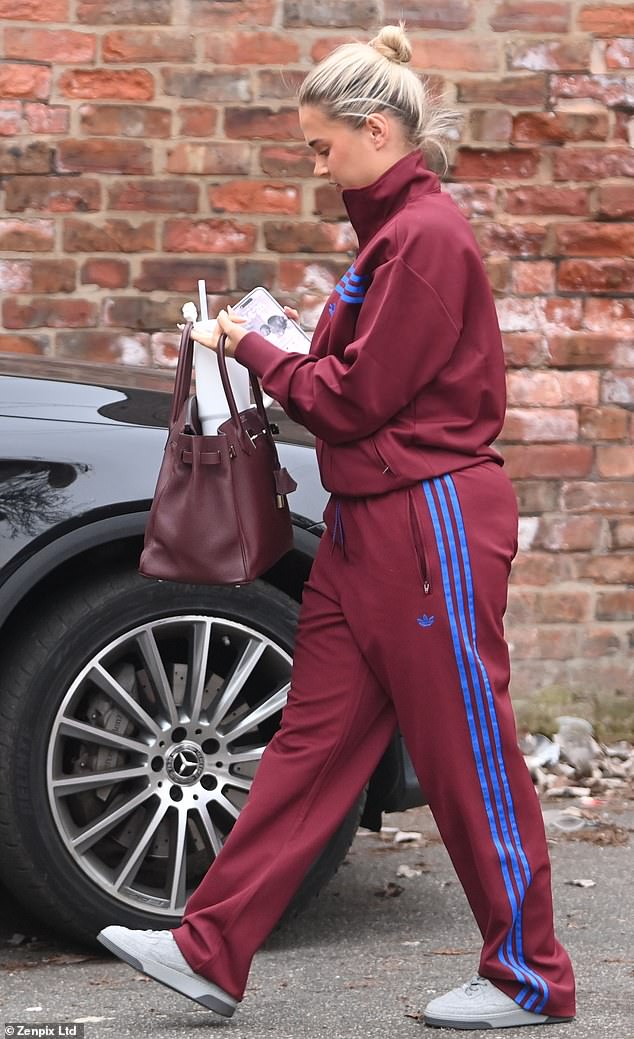 The mother-of-one was seen trying to fit her large reusable cup into her designer bag as she walked to her £200k G Wagon.