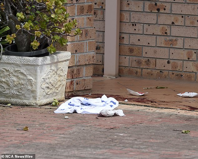 Blood-stained rags and paper towels were seen outside a home on Spring Street.