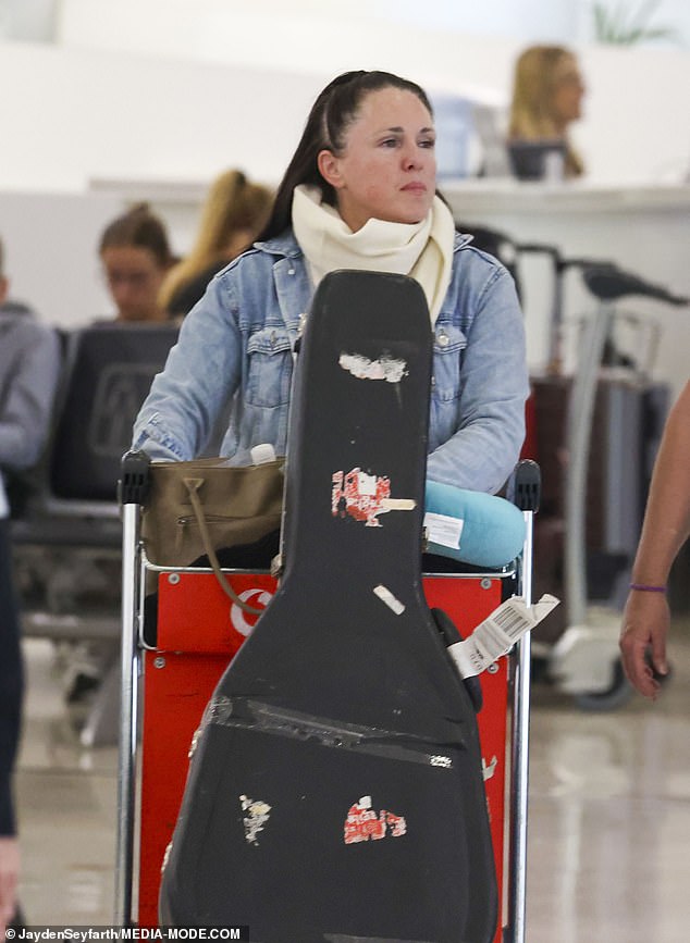 She completed her look with gray sneakers and a large white scarf around her neck.