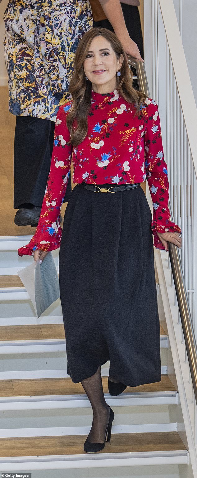 She wore a floral-print silk blouse by Erdem Lindsay Hideko that she tucked into a long black belted skirt, which showed off her slender figure.