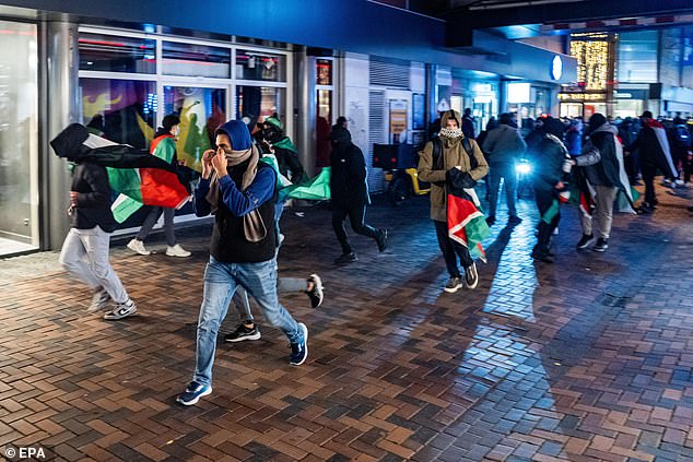 Protesters run with Palestinian flags before the UEFA Europa League match between Ajax and Maccabi Tel Aviv at Anton de Komplein in Amsterdam, Netherlands, on November 7, 2024.