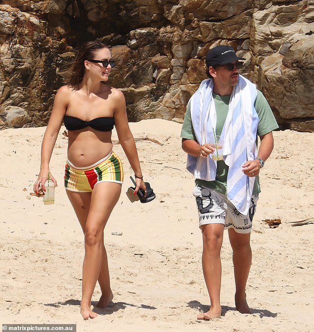 The fitness influencer looked sensational as she flaunted her growing baby bump with husband Josh Miller. Steph, 30, made sure all eyes were on her as she strolled along the beach in a bandeau bikini teamed with colorful striped shorts.