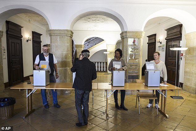 The Swiss People's Party (SVP), which is the largest in the four-party ruling coalition, launched the anti-immigration initiative last year, which was signed by more than 115,000 residents and could be on the ballot as early as 2026 (file image of a Swiss voter casting his vote during the October 2023 federal election)