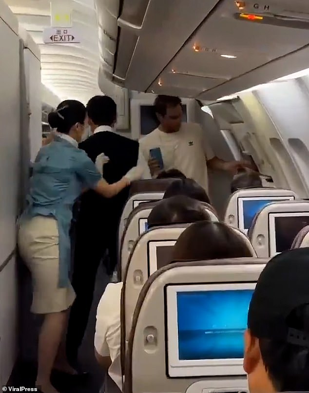 A flight attendant goes to arrest the man, who allegedly threatened one of the crew members after sitting in his seat.