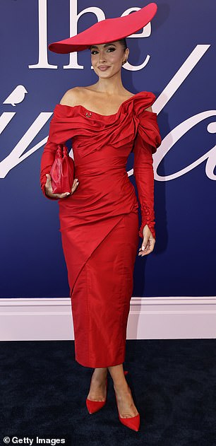 Meanwhile, model Olivia Molly Rogers, 32, wore a bright red strapless long-sleeved maxi dress with a clutch and pointed heels.