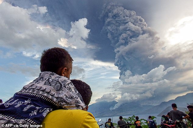 Residents watch the eruption of Mount Lewotobi Laki Laki from Eputobi village.