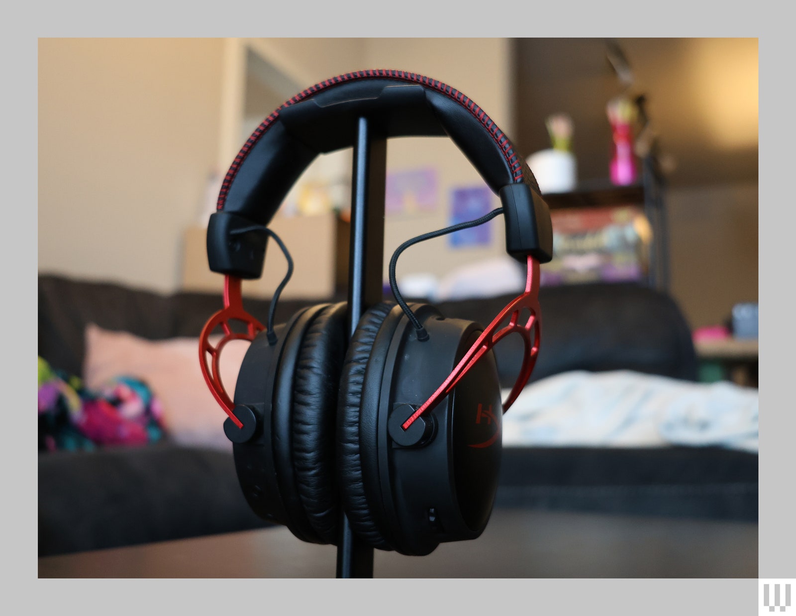 Headphones with black padded headband, red connectors between the headband and headphones, and black padded earcups. TO...