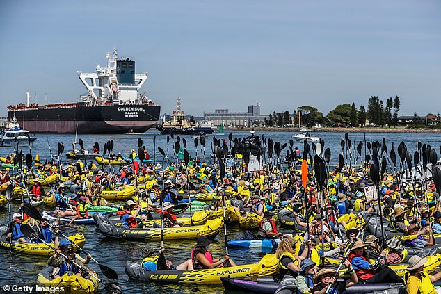 There were about 150 people waving anti-coal signs and paddling toward the canal in kayaks. Police used jet skis and police boats to arrest protesters (protesters pictured gathering in Newcastle Harbour)