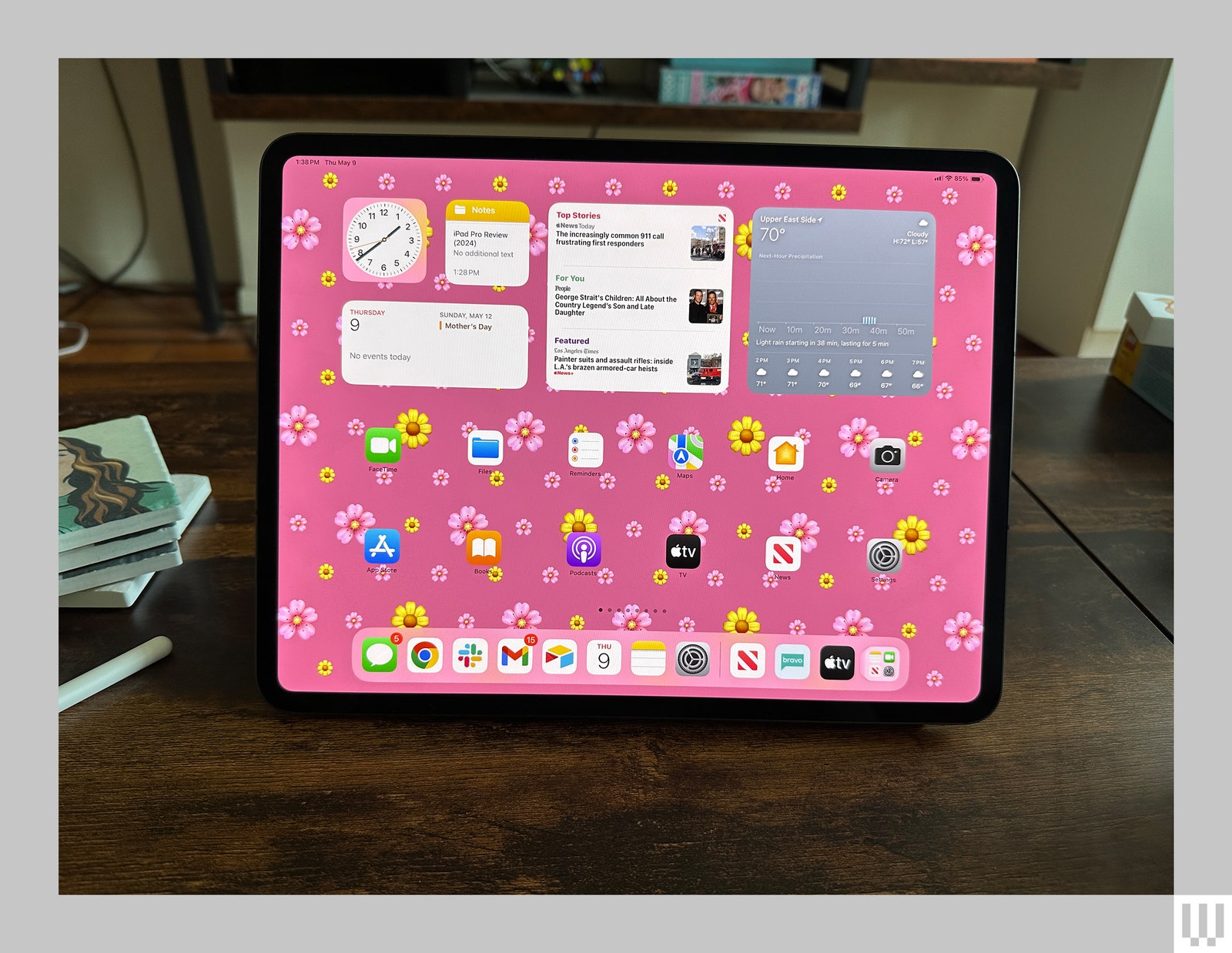 Front view of black tablet with floral print on screen background and app icons