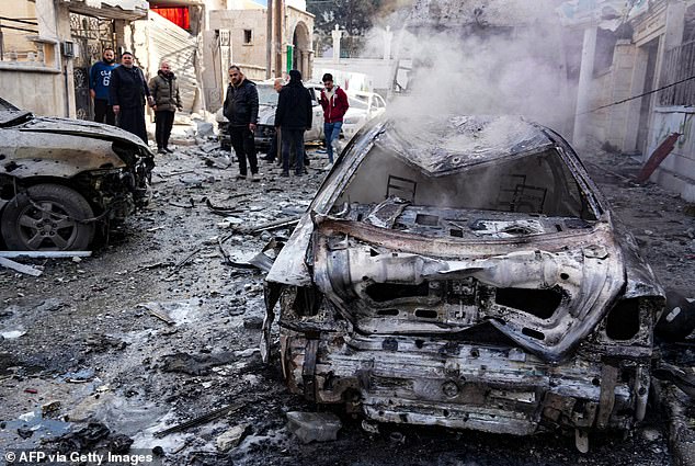 People check damage at the site of a Syrian regime air force strike that targeted a neighborhood in the rebel-held northern Syrian city of Idlib on December 1, 2024.