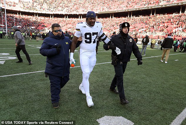 Michigan defensive end Chibi Anwunah is escorted off the field after being pepper-sprayed