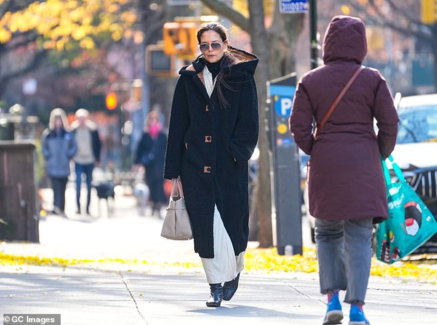 The coat extended a few inches above Katie's ankles and revealed the white skirt she was wearing underneath.