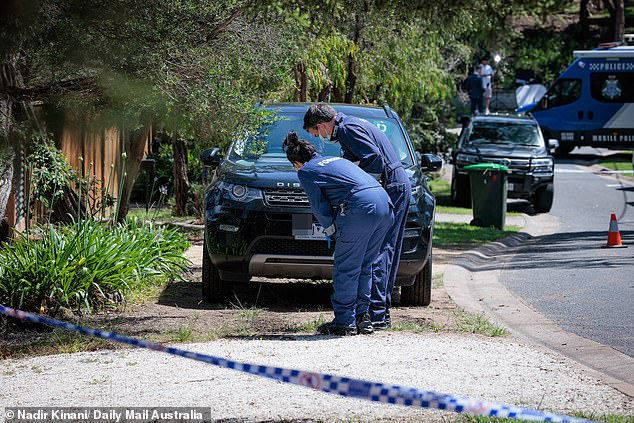 Forensic officers are seen examining a car with a P plate that was parked outside the property.