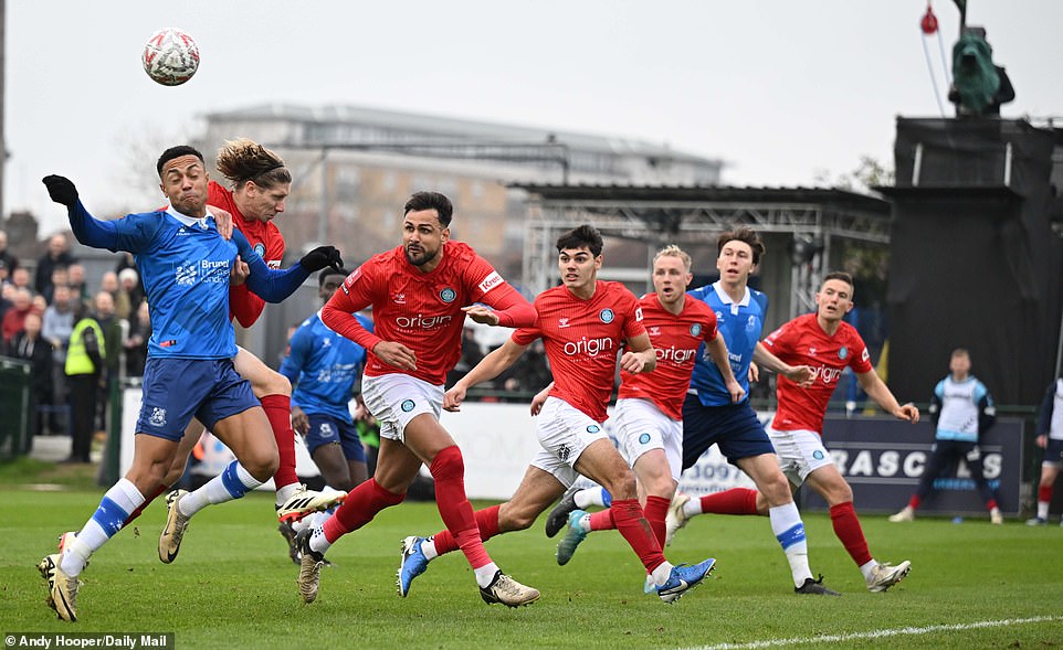 Players compete for the ball after a cross is sent into a dangerous area of ​​the Wycombe box, as the visitors maintain a tight line.