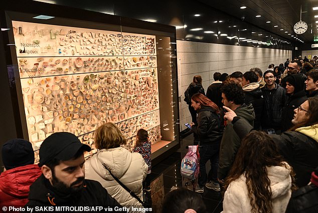 Travelers view some of the objects from the Byzantine and Roman periods found during construction at the Agia Sofia metro station.