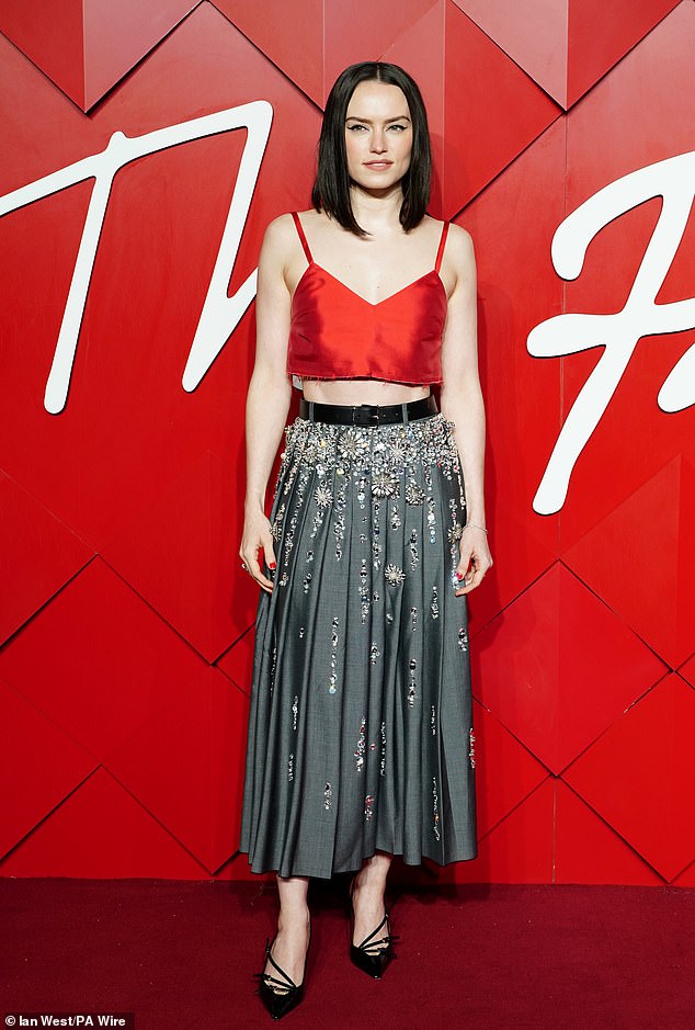 Daisy Ridley kept it simple in a red silk crop top and a long dark gray pleated skirt embellished with silver sequins.