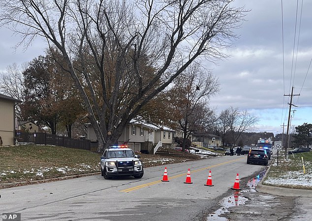 Police are seen at the former officer's home on Monday. A warrant was issued for his arrest after he failed to appear in court