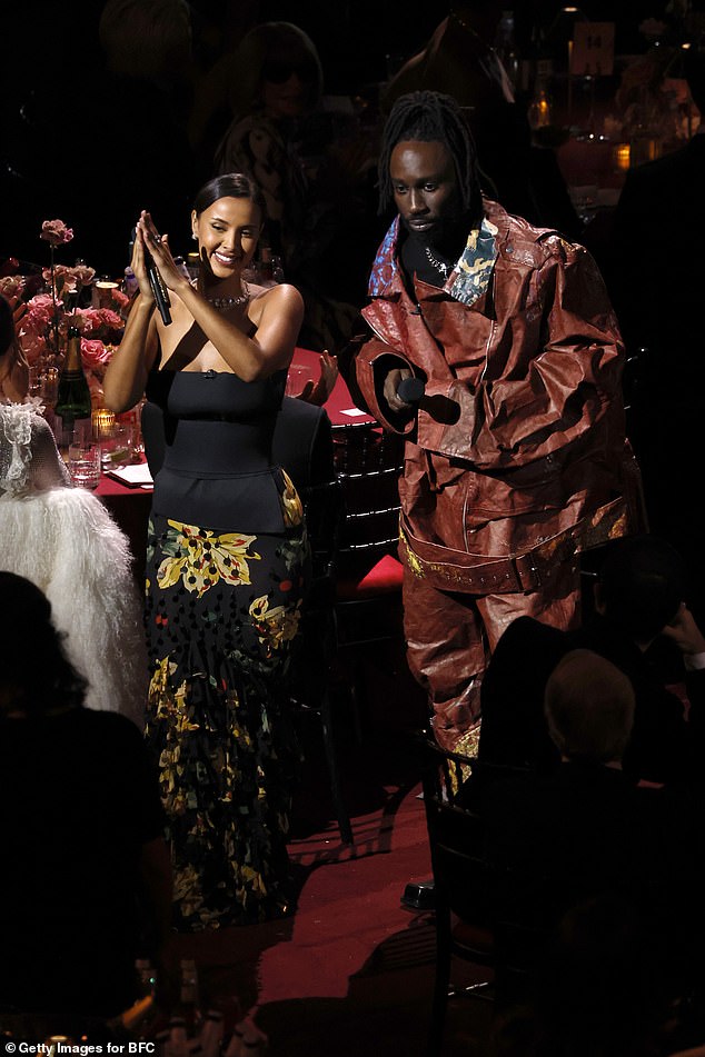 The strapless top highlighted her slender waist and she paired it with a ruffled maxi skirt covered in yellow flowers and hundreds of sequins.