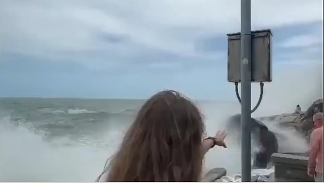 A woman is seen reaching out as the waves crash around Kamilla, with no one nearby able to help her.