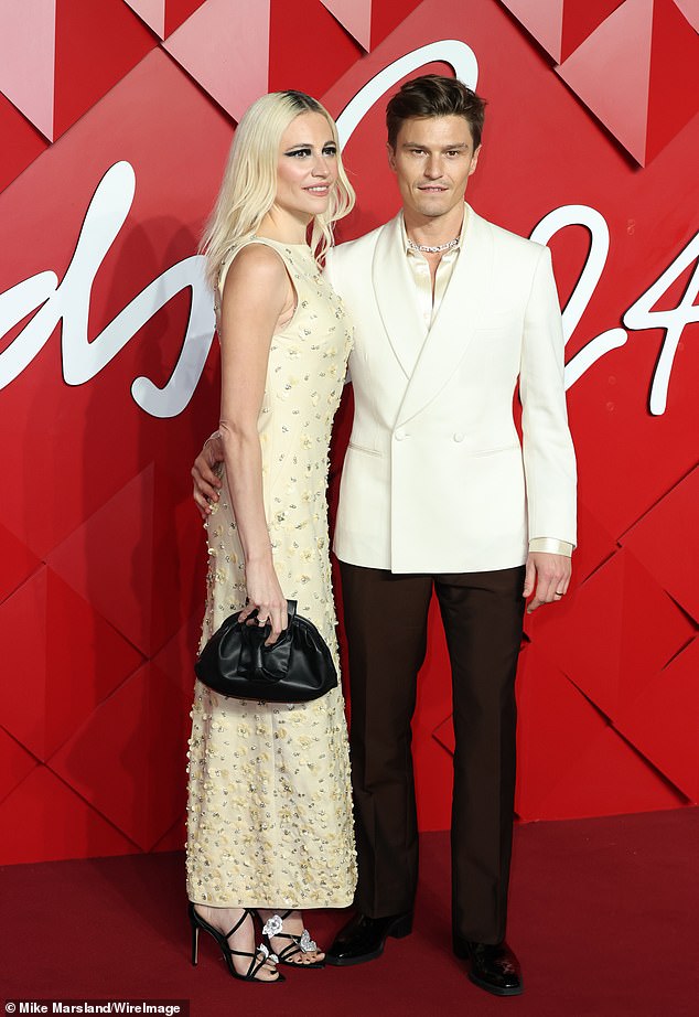 Meanwhile, model Oliver, 36, cut a dapper figure in a tailored white jacket which he teamed with a gold silk shirt and smart black trousers.