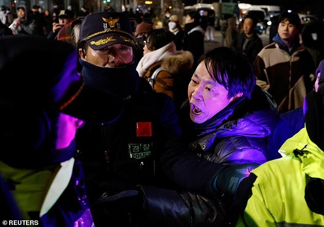 A man confronts police officers outside the National Assembly after South Korean President Yoon Suk Yeol declared martial law in Seoul.