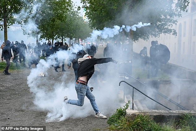 A protester fires a tear gas canister during clashes with police during a demonstration in Nantes last year.