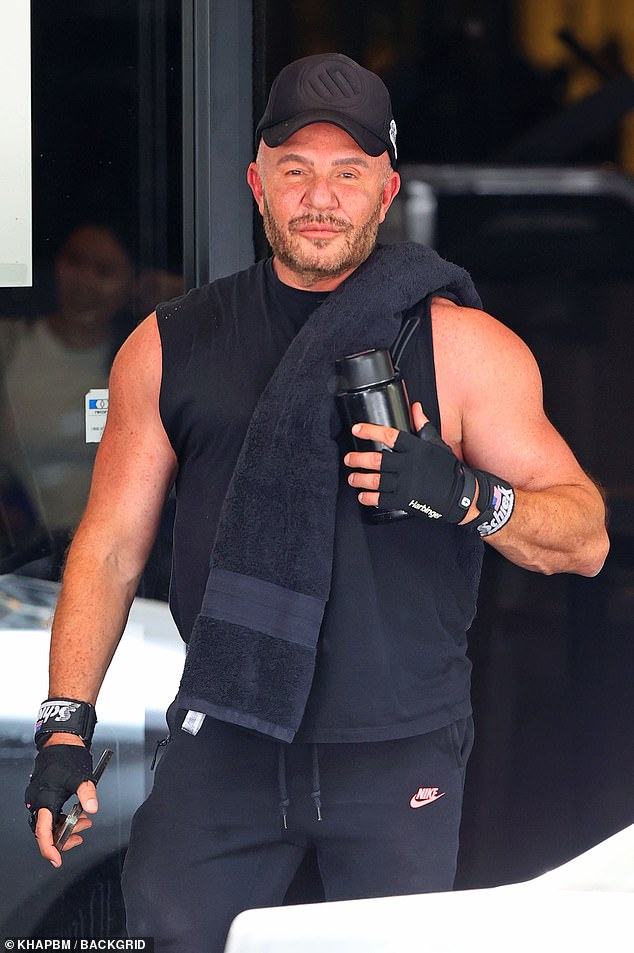 With a towel over one shoulder, Alex accessorized with fitness bands on each wrist and also carried a mobile device and a water bottle.