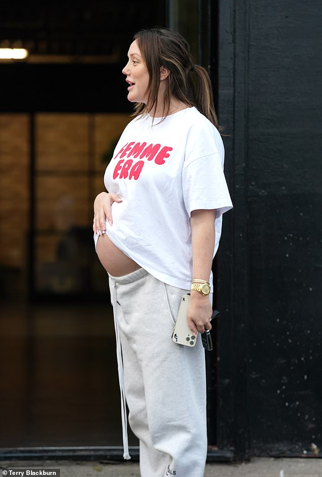 Charlotte showed off a glimpse of her baby bump in an oversized white t-shirt as she walked out with her security guards.