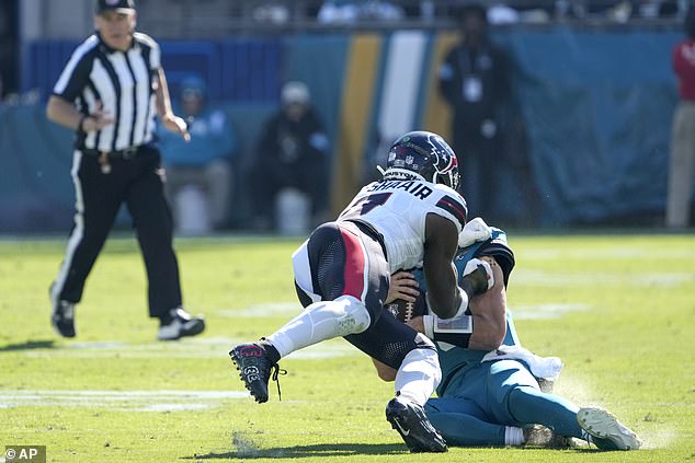 Jacksonville Jaguars quarterback Trevor Lawrence (16) slides down as Houston Texans linebacker Azeez Al-Shaair (0) advances during Sunday's game in Florida.