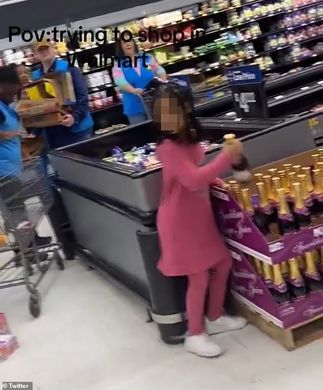 The child began grabbing glass bottles of sparkling juice and throwing them on the ground before a man intervened