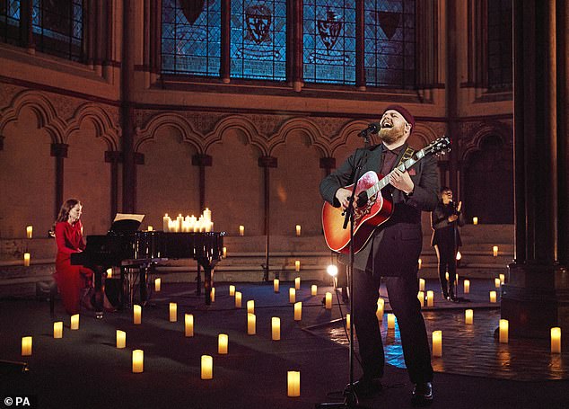 Kate plays the piano in the candlelit abbey while Tom Walker sings and plays guitar