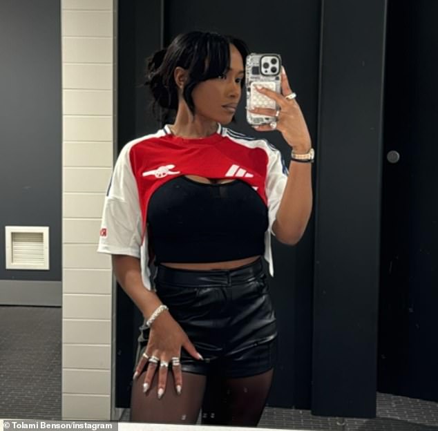 The PR executive showed off her curves in a pair of black leather shorts and a custom Gunners t-shirt, designed to reveal her busty black tank top.