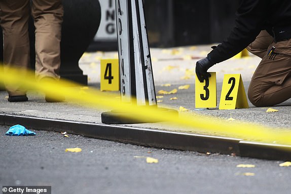 NEW YORK, NEW YORK - DECEMBER 04: Police place bullet casing markers outside a Hilton Hotel in Midtown Manhattan where United Healthcare CEO Brian Thompson was fatally shot on December 4, 2024 in New York City. Brian Thompson was shot dead outside the Hilton Hotel before 7am this morning, just before he was due to attend the company's annual investor meeting. (Photo by Spencer Platt/Getty Images)