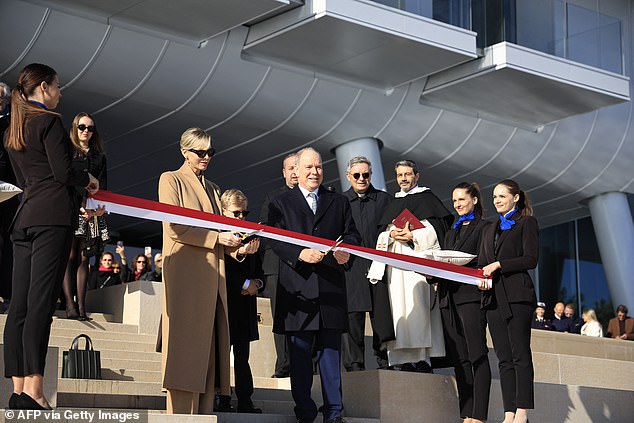 Prince Albert II of Monaco (center) cuts the ribbon alongside Princess Charlene of Monaco (left) and Prince Jacques (center) during the inauguration of the new 'Mareterra' district in Monaco, December 4, 2024.