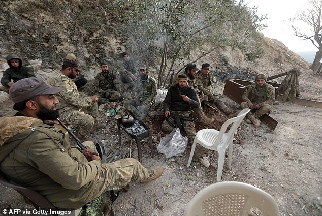 Anti-government fighters rest in a position on the northern outskirts of the city of Hama in west-central Syria on December 4, 2024.