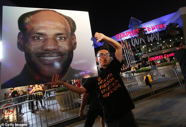 A pro-Hong Kong activist holds a photo depicting LeBron James as Chinese Communist Revolutionary Chairman Mao Zedong before the Los Angeles Lakers' season-opening game against the LA Clippers, outside Staples Center, on October 22, 2019