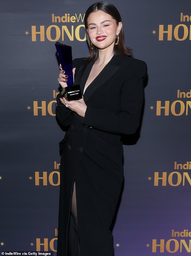 Now Selena is collecting her latest award for the film and posed proudly with the trophy in front of an Indiewire backdrop on Thursday.