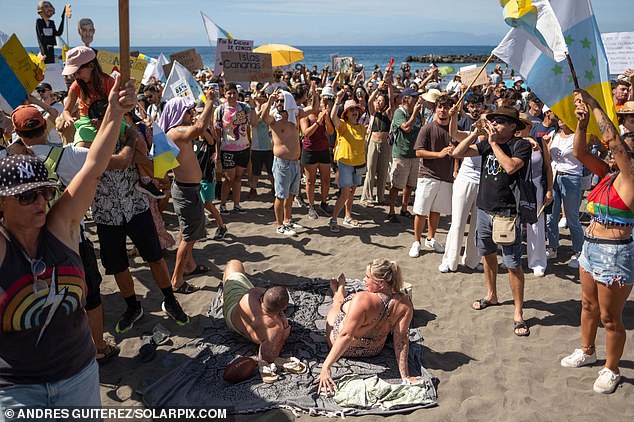 Noisy protesters stormed a Tenerife beach in October during a new march against mass tourism as shocked tourists sunbathing under a blue sky looked on.