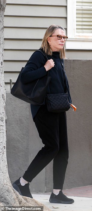 She looked comfortable in a black wool jacket that she wore with simple black pants and black slip-on sneakers.