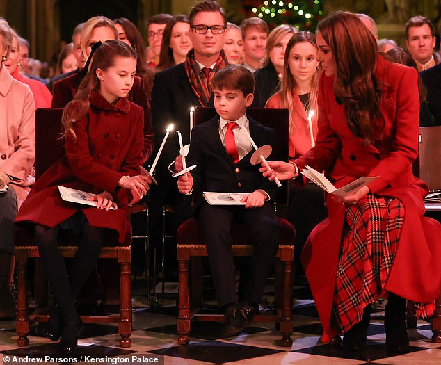 The Princess of Wales sat opposite Prince Louis and Princess Charlotte, who matched their mother's red ensemble, during the Christmas carol concert