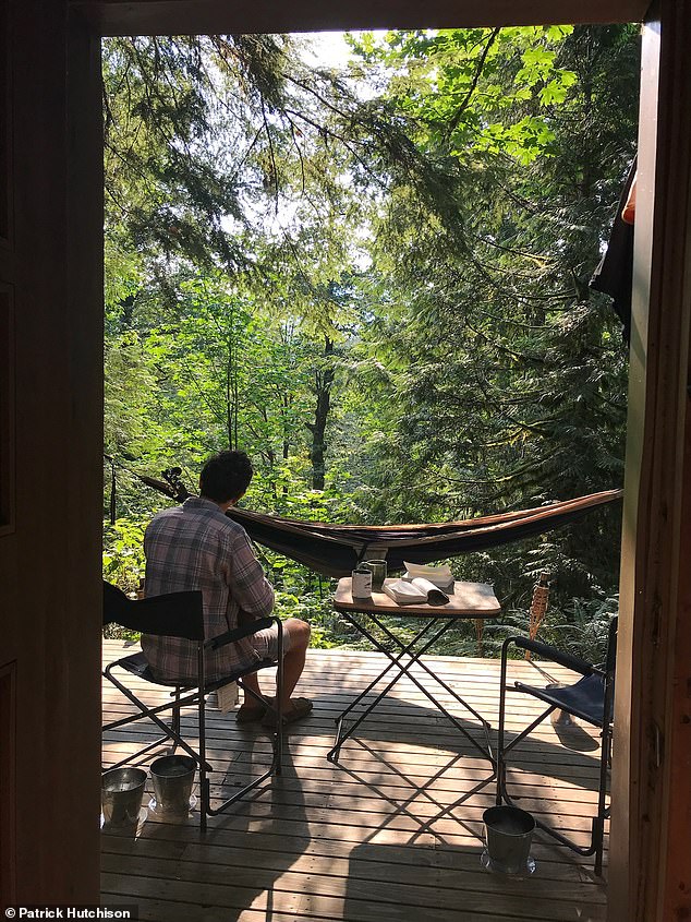 Hutchison's cabin building partner Bryan Schatz enjoys breakfast on the deck of the newly renovated cabin