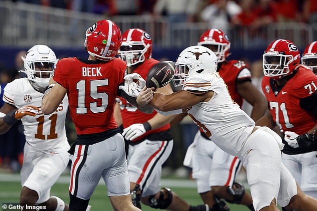 Texas Longhorns' Trey Moore #8 tackles Carson Beck #15 on the final play of the first half