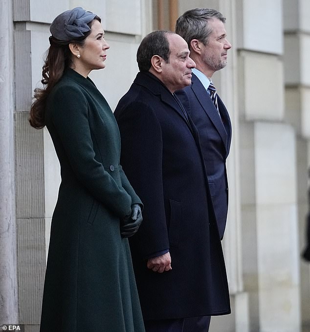 Queen Mary looked festive in an elegant green coat that cinched at the waist and fell just below the knee.