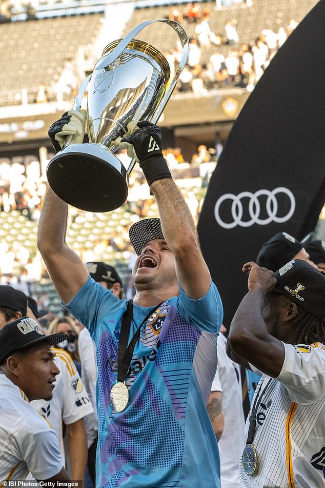 John McCarthy #77 of Los Angeles Galaxy lifts the MLS Cup after Saturday's victory