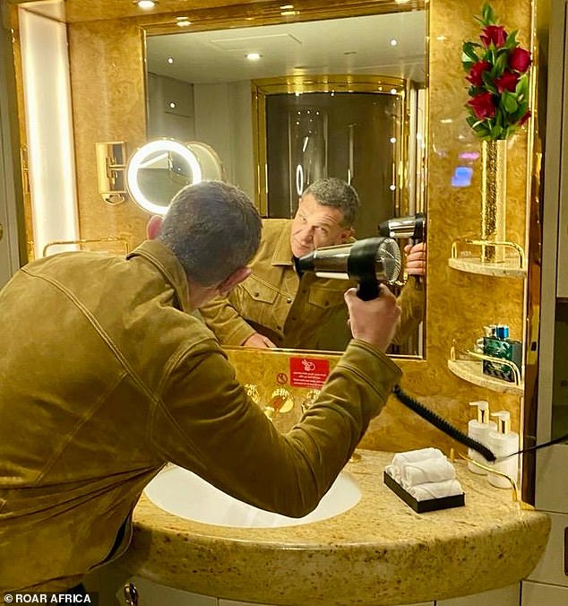 A guest uses the hairdryer in the private jet's 'spa shower'