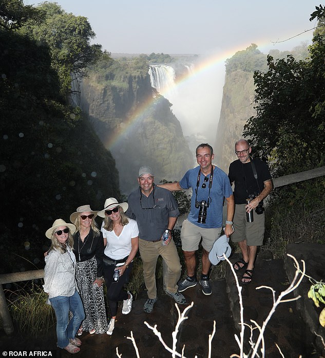 Roar Africa guests pose in front of the epic cliffs of Victoria Falls