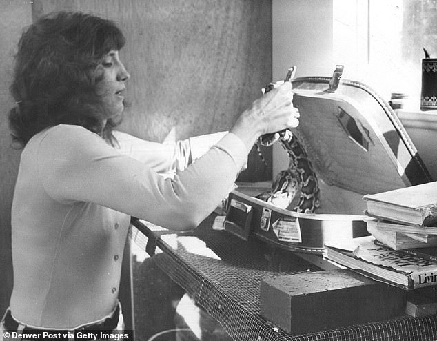 Pictured is Mary Rollins putting a Burmese python in a suitcase in September 1981.