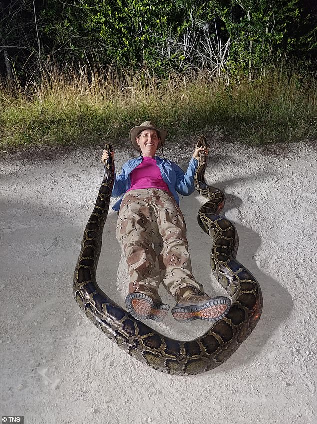 Donna Kalil poses with one of her captures. Kalil is a hunter for the South Florida Water Management District's python removal program.